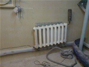 Un ejemplo de instalación de un calentador en un radiador de hierro fundido